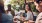 a group of people sitting around a table with food